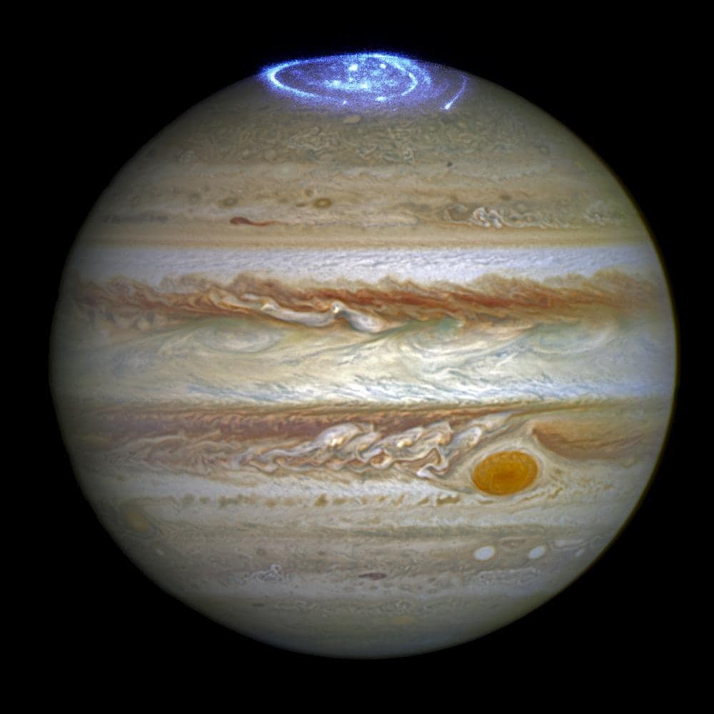 polos do maior planeta do sistema solar, Júpiter. As auroras foram fotografadas durante uma série de observações em luz ultravioleta distante realizadas pelo Telescópio Espacial Hubble enquanto a sonda espacial Juno da NASA se aproximava e entrava em órbita ao redor de Júpiter em 2016. O objetivo do programa era determinar como as auroras de Júpiter respondem às mudanças nas condições do vento solar, um fluxo de partículas carregadas emitidas pelo Sol. As auroras se formam quando partículas carregadas no espaço ao redor do planeta são aceleradas a altas energias ao longo do campo magnético do planeta. Quando as partículas atingem a atmosfera perto dos polos magnéticos, elas a fazem brilhar como gases em uma luminária fluorescente.