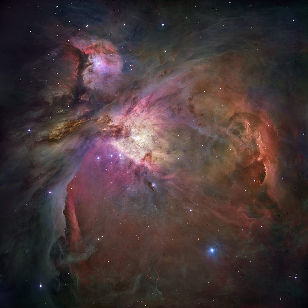 A Nebulosa de Órion Imagem colorida da Nebulosa de Órion capturada pelo Hubble, revelando nuvens de gás interestelar em tons vibrantes de rosa, azul e roxo, onde novas estrelas estão se formando.