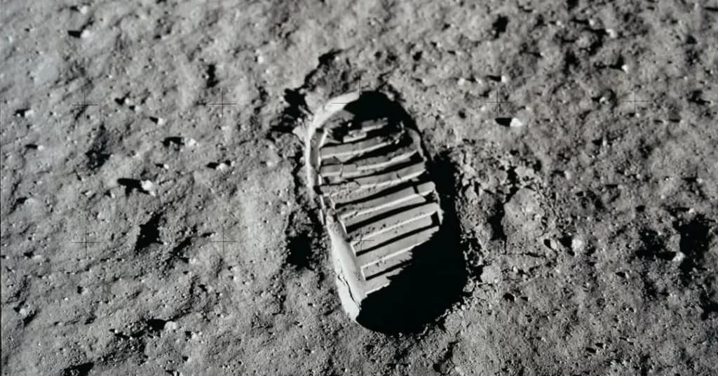 Pegada bem definida de um astronauta da Apollo 11 na superfície da Lua, destacando os sulcos da bota no solo poeirento e granular do regolito lunar. A iluminação lateral realça os detalhes da marca deixada na história da exploração espacial.