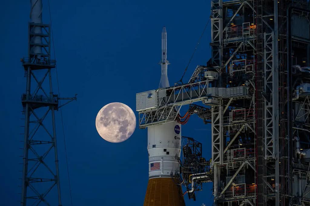 Uma lua cheia era visível atrás do foguete Artemis I SLS (Sistema de Lançamento Espacial) e da nave espacial Orion no Complexo de Lançamento 39B no Centro Espacial Kennedy da NASA, na Flórida, em 14 de junho de 2022. A primeira de uma série cada vez mais complexa de missões, a Artemis I testou o SLS e a Orion como um sistema integrado antes dos voos tripulados para a Lua.