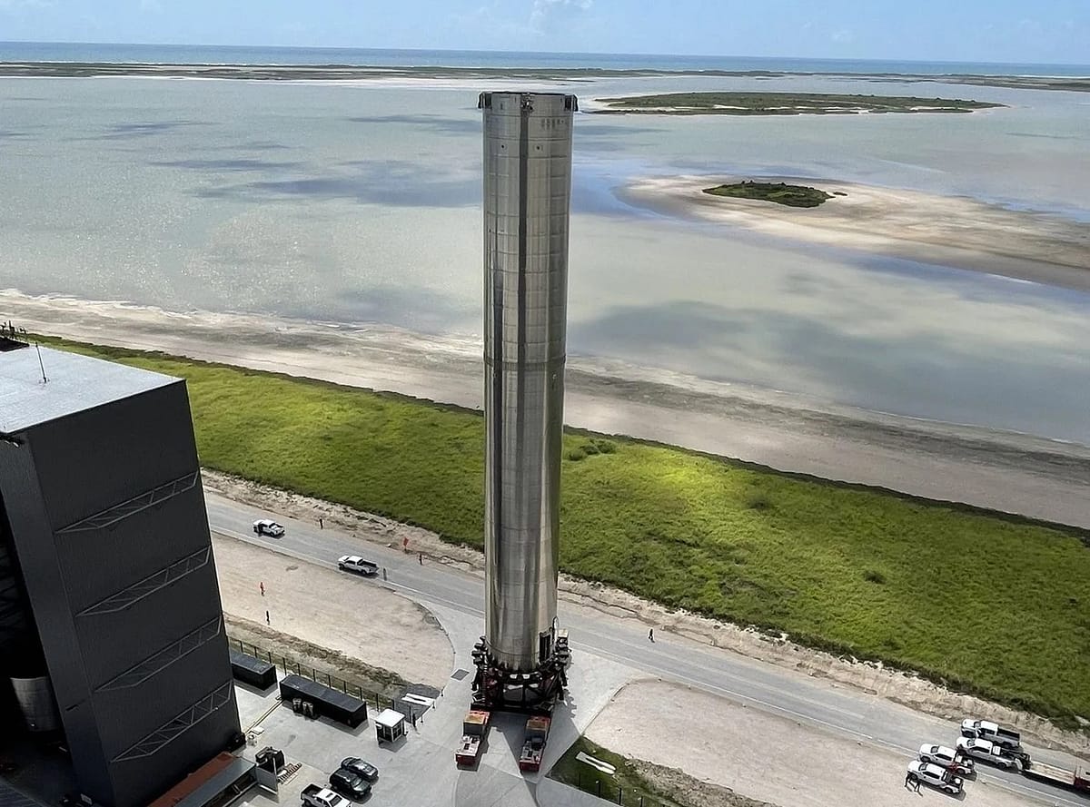 Boost Super Heavy sendo transportado para a base de lançamento Starbase, localizada no Texas, EUA. O foguete Starship, projetado pela SpaceX, está sendo preparado para futuras missões espaciais, incluindo viagens à Lua, Marte e além, destacando o avanço da exploração espacial