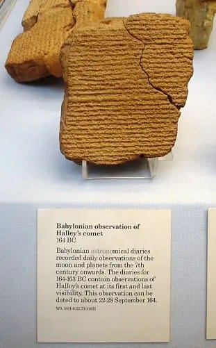 alt="Registros babilônios em cuneiforme documentando a passagem do cometa Halley, gravados em duas "pedras" de argila, com símbolos e escritos antigos representando observações astronômicas detalhadas feitas pelos babilônios."