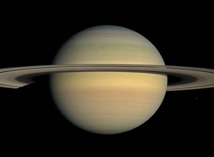 Saturno, capturado pelo Telescópio Espacial Hubble, mostrando o planeta com seus icônicos anéis e várias das suas luas mais importantes, como Titã, Encélado, Mimas e Dione. O contraste entre os anéis brilhantes de Saturno e as luas visíveis em torno do planeta oferece uma visão impressionante da complexidade do sistema de Saturno