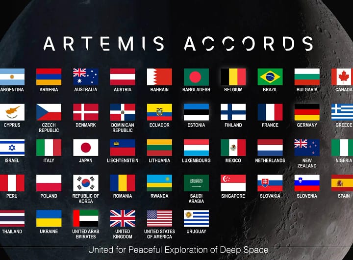 Este gráfico exibe as bandeiras das nações que assinaram os Acordos Artemis, sobre uma imagem de fundo da Lua no espaço negro. O gráfico tem o título 'Acordos Artemis'. As palavras 'Unidos pela Exploração Pacífica do Espaço Profundo' aparecem na parte inferior da imagem. creditos NASA