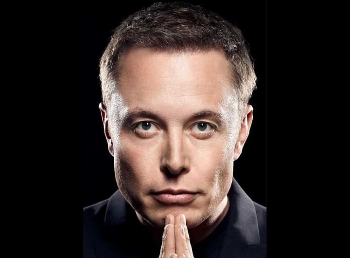 Elon Musk de terno em um evento, segurando um copo de café e com expressão pensativa, como se refletisse sobre algo importante.
