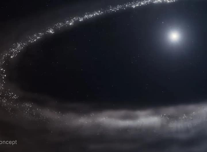 Ilustração da estrela semelhante ao Sol HD 181327 e seu disco de detritos ao redor. A estrela está no canto superior direito. Ela é cercada por um disco de detritos muito maior, que forma um caminho elíptico incompleto e é cortado à direita. Há uma enorme cavidade entre a estrela e o disco. O disco de detritos é mostrado em tons de cinza claro. Na parte superior e à esquerda, há pontos mais finos e distintos, em uma variedade de tamanhos. O disco parece mais nebuloso e esfumaçado na parte inferior. A estrela é branca brilhante no centro, com uma região azulada ao seu redor. O fundo do espaço é preto. A legenda 'Conceito Artístico' aparece no canto inferior esquerdo. James Webb Detecta Gelo de Água Cristalina