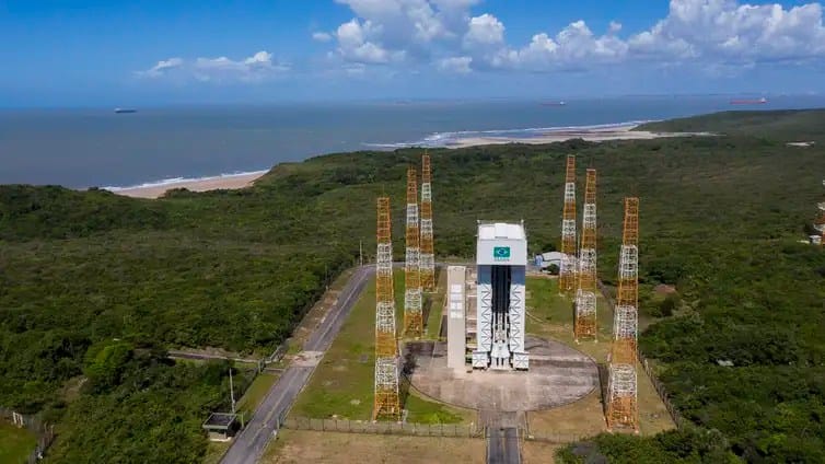 Imagem aérea do Centro de Lançamento de Alcântara, no Maranhão, mostrando as plataformas de lançamento, instalações técnicas e a paisagem litorânea ao redor.