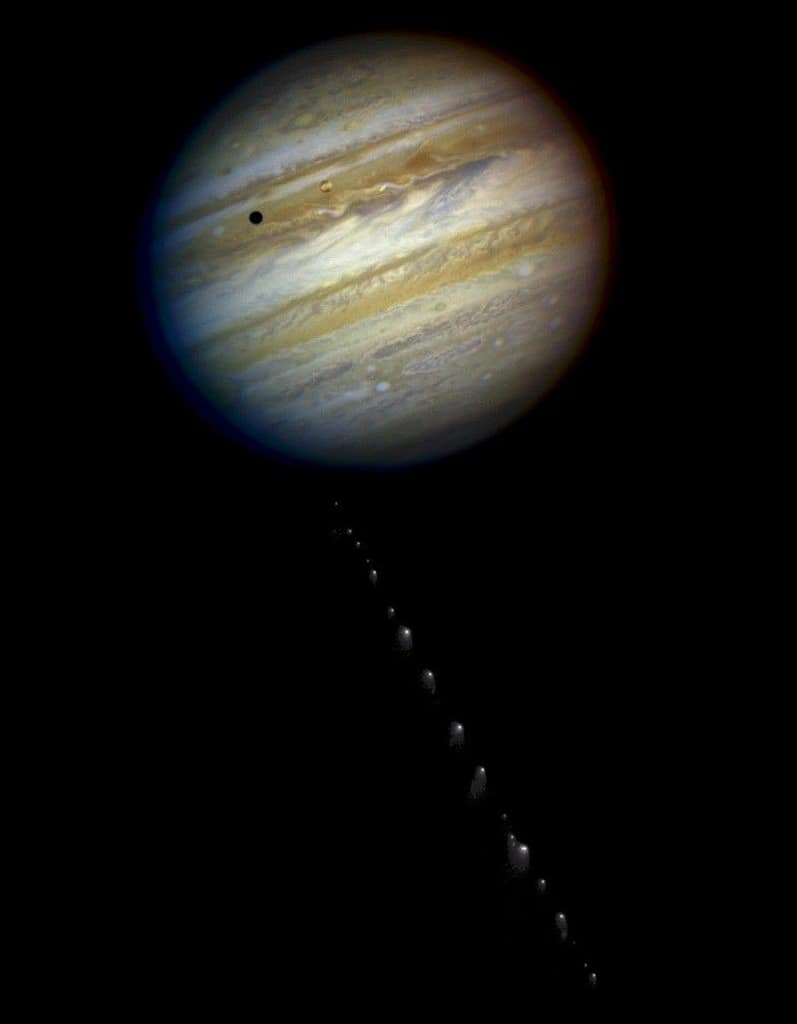 Esta é uma foto composta de imagens separadas de Júpiter e do cometa Shoemaker-Levy 9, tiradas pelo Telescópio Espacial Hubble. A imagem mostra 21 fragmentos do cometa. A mancha escura no planeta é a sombra de Ío, uma das maiores luas de Júpiter. A imagem do cometa, que exibe os 21 fragmentos, foi tirada em 17 de maio de 1994. A imagem de Júpiter foi tirada em 18 de maio de 1994.
NASA, ESA, H. Weaver e E. Smith (STScI) e J. Trauger e R. Evans (Laboratório de Propulsão a Jato da NASA)