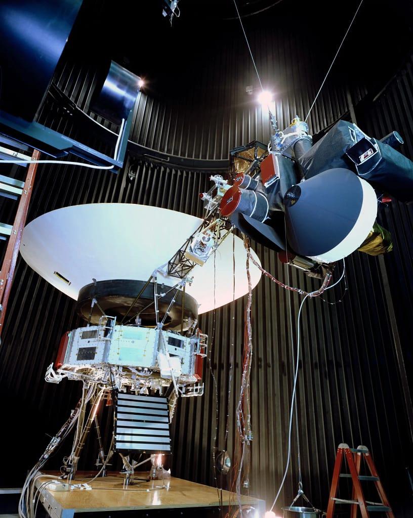 Esta foto de arquivo mostra o modelo de teste de validação da Voyager, que não foi lançado ao espaço, na câmara simuladora espacial de 25 pés do Laboratório de Propulsão a Jato da NASA, em Pasadena, Califórnia, em 3 de dezembro de 1976. A espaçonave é vista aqui com sua plataforma de varredura — que abriga vários de seus instrumentos científicos — na posição desdobrada. Sondas Voyager da NASA e a contribuição para Astronomia.