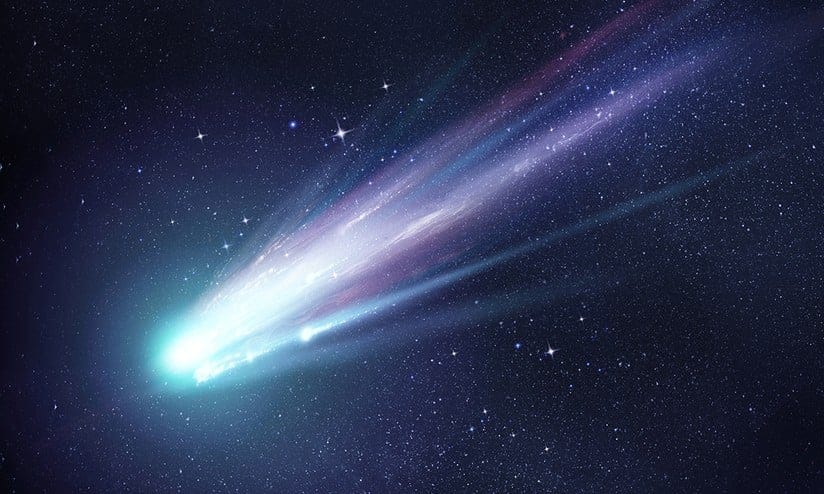 Cometa azul com cauda brilhante, representação artística do cometa interestelar 3I/ATLAS, viajando pelo espaço com o universo estrelado ao fundo.