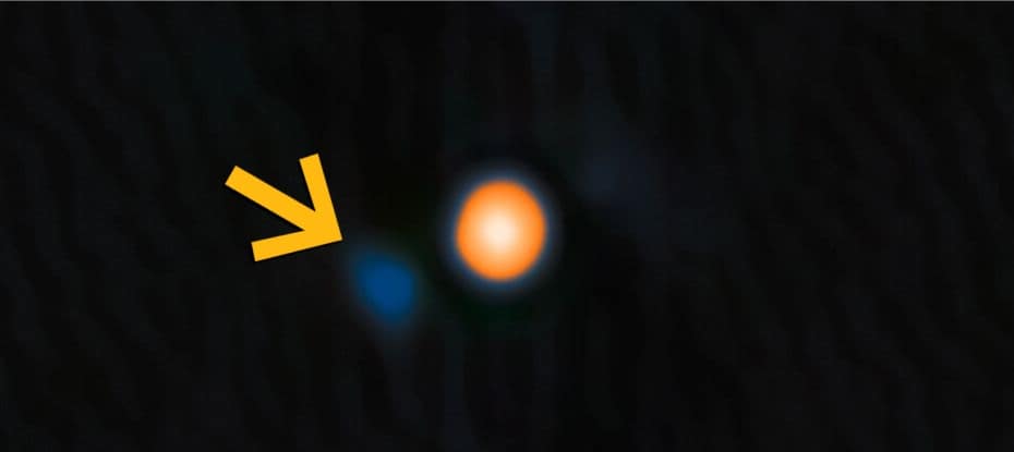 Imagem da estrela Betelgeuse em tons amarelo-avermelhados. Uma seta amarela destaca sua estrela companheira próxima, visível como um ponto azul tênue. Dados: NASA, JPL e NOIRLab; visualização: NOIRLab.