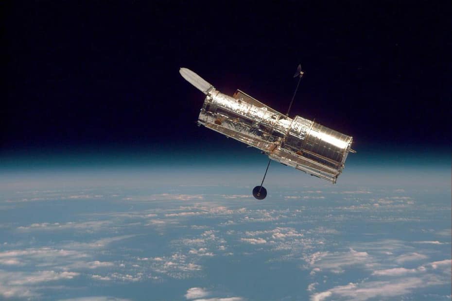 magem icônica da NASA do Telescópio Hubble, capturando a curvatura da Terra e a camada fina da atmosfera terrestre. A foto destaca a beleza da nossa planeta visto do espaço, com a linha do horizonte da Terra se misturando com a escuridão do cosmos.