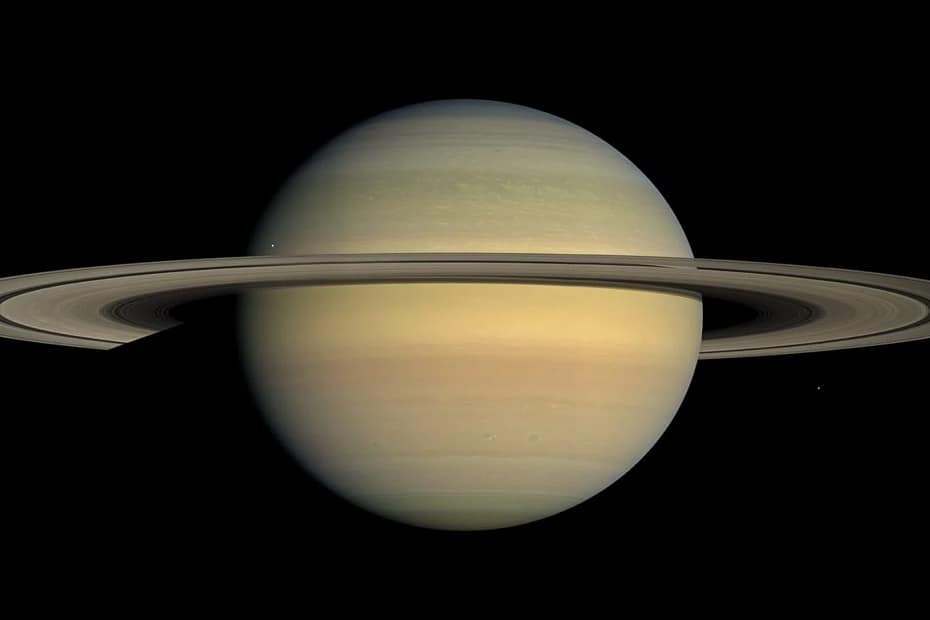 Saturno, capturado pelo Telescópio Espacial Hubble, mostrando o planeta com seus icônicos anéis e várias das suas luas mais importantes, como Titã, Encélado, Mimas e Dione. O contraste entre os anéis brilhantes de Saturno e as luas visíveis em torno do planeta oferece uma visão impressionante da complexidade do sistema de Saturno