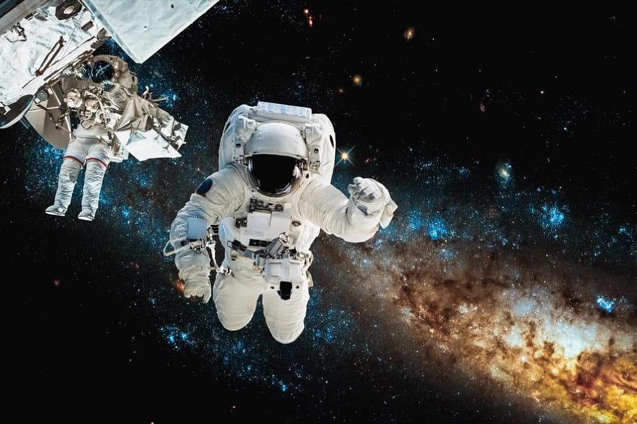 Astronauta flutuando no espaço visto através da janela da ISS, com a Via Láctea brilhando ao fundo — simbolizando a astronomia na exploração espacial.