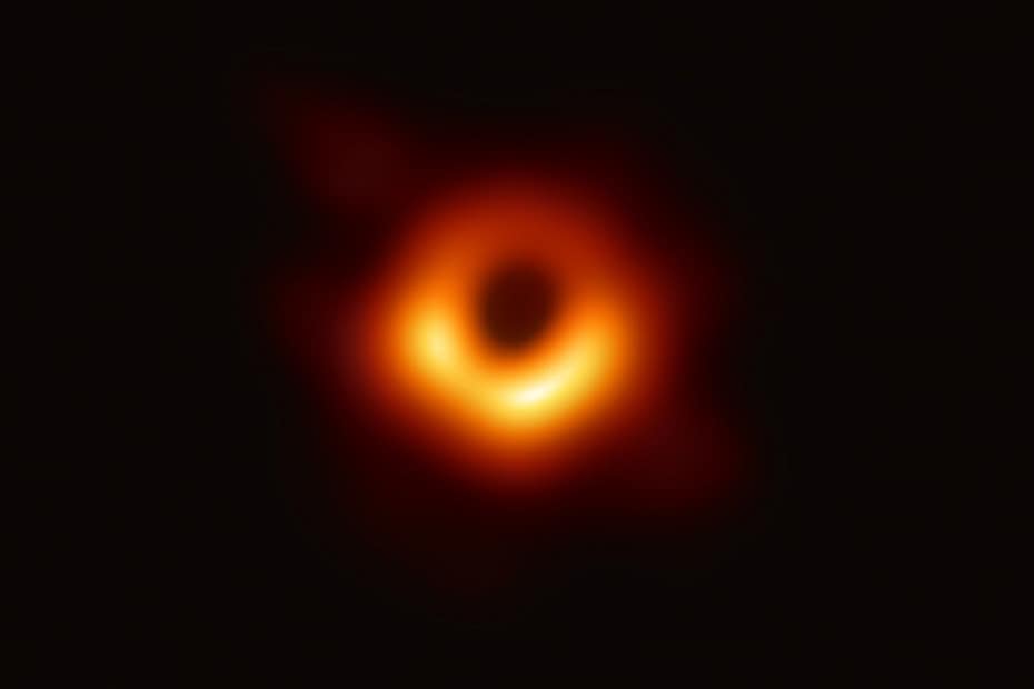 Primeira imagem real de um buraco negro, capturada em 2019 pelo projeto Event Horizon Telescope, mostrando a silhueta do buraco negro da galáxia M87 com um anel de luz brilhante ao redor da sua sombra.