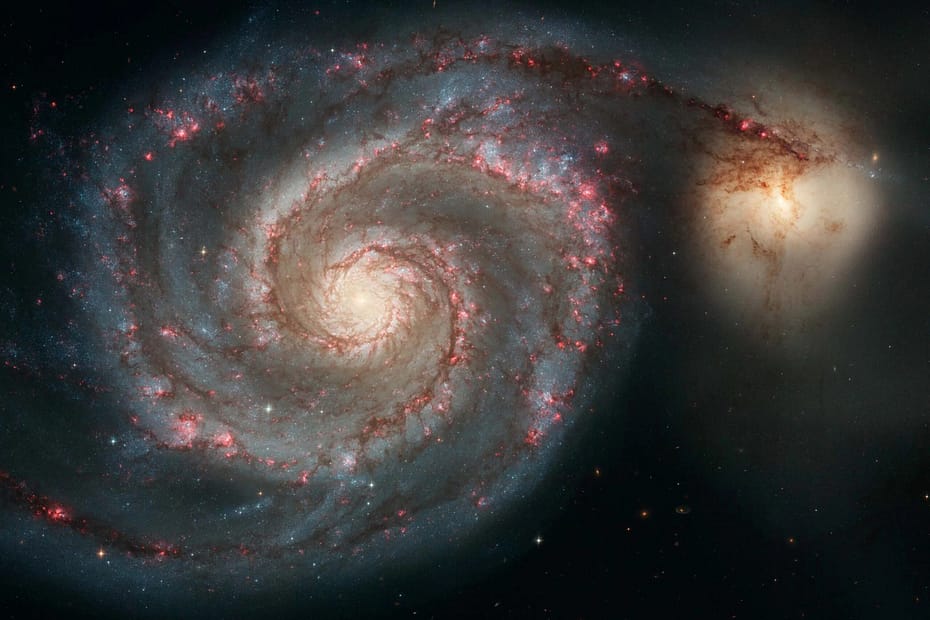 A Galáxia do Redemoinho, M51, é uma galáxia espiral localizada a 31 milhões de anos-luz de distância. Ela destaca os atributos de uma galáxia espiral típica, incluindo braços graciosos e curvos, regiões cor-de-rosa de formação estelar e brilhantes filamentos azuis de aglomerados estelares.