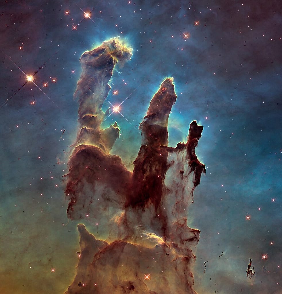 Os Pilares da Criação Registro icônico dos Pilares da Criação na Nebulosa da Águia, com colunas de gás e poeira moldadas pela radiação estelar, mostrando a formação de estrelas em tempo real.