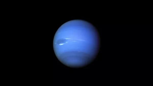 magem detalhada de Netuno, capturada pela NASA, mostrando o planeta azul profundo com suas características atmosferas e nuvens densas. O planeta é envolto por uma fina camada de anéis, quase imperceptíveis a olho nu, e a imagem destaca as cores vibrantes e os detalhes da atmosfera turbulenta de Netuno.