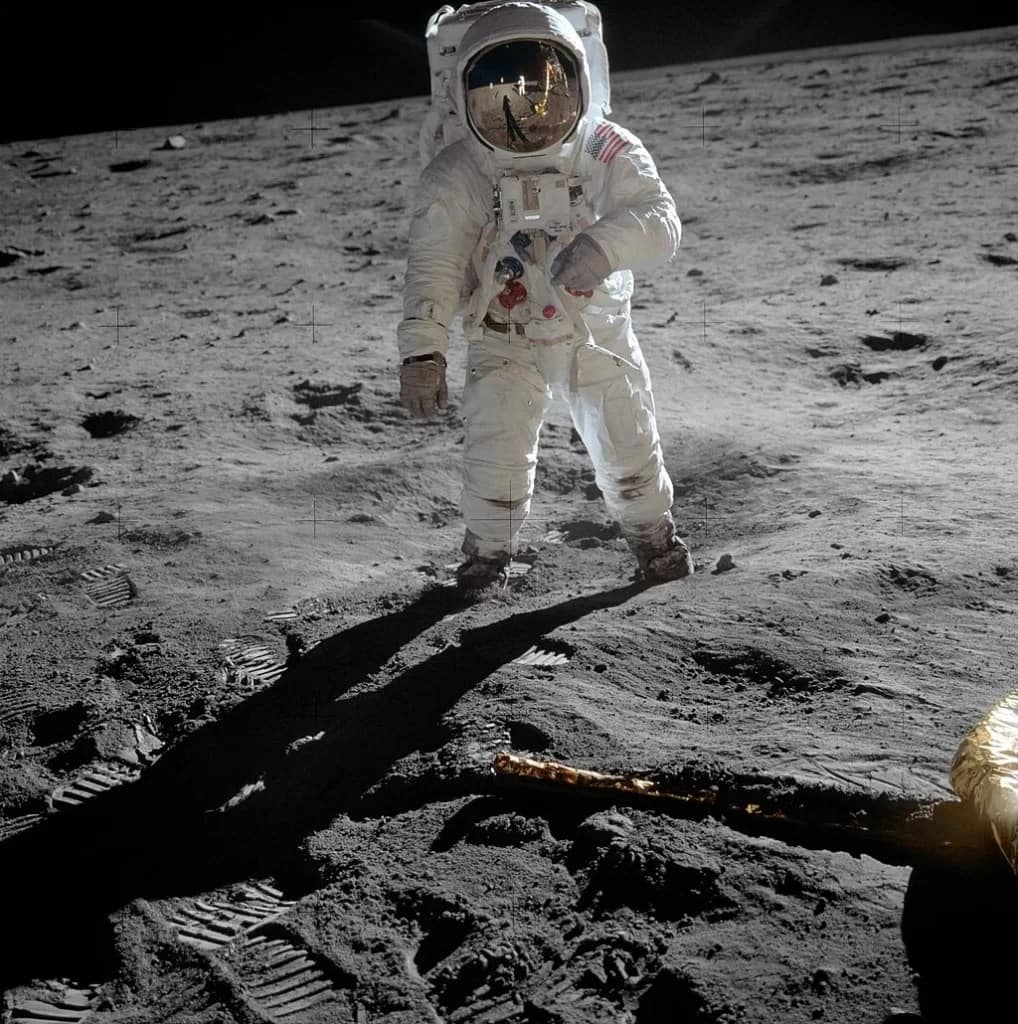 Foto icônica de Buzz Aldrin em traje de astronauta completo durante o primeiro pouso na Lua em julho de 1969. A imagem foi tirada por Neil Armstrong, que pode ser visto no visor do capacete de Aldrin. Armstrong usou uma câmera Hasselblad para capturar esse momento histórico. A foto reflete um dos marcos mais significativos da exploração espacial.