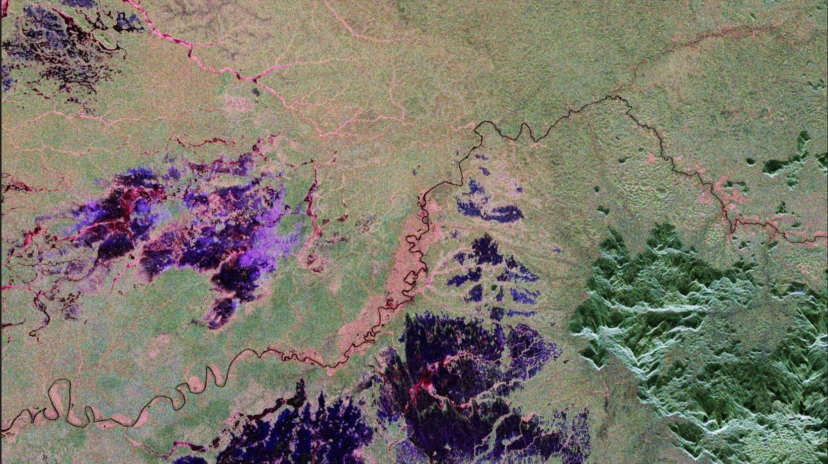 Primeira imagem capturada pelo satélite Biomass da ESA, mostrando a Floresta Amazônica no norte do Brasil. Tons de verde indicam floresta densa, enquanto áreas vermelhas e rosas revelam planícies alagadas e regiões de várzea detectadas sob a copa das árvores.