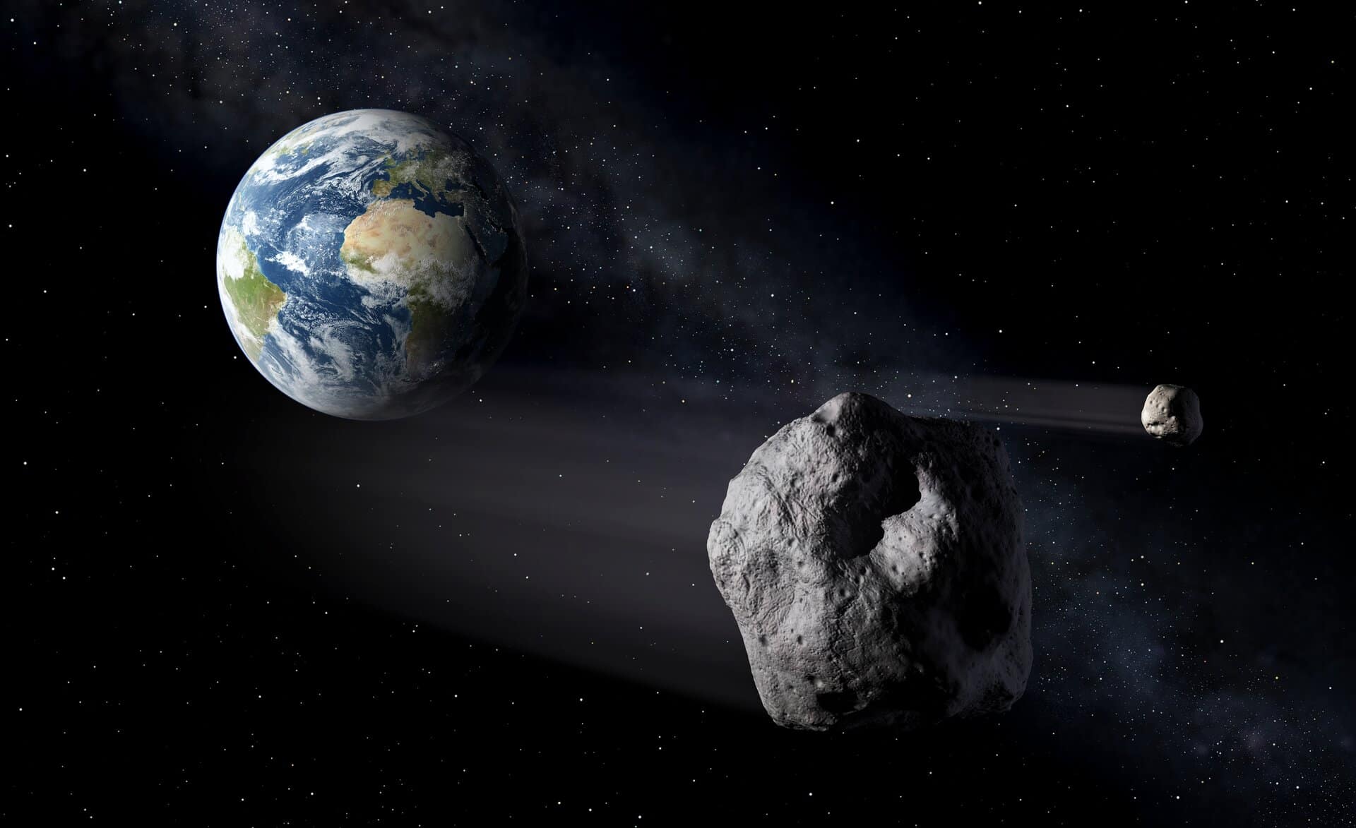Ilustração mostrando a Terra vista do espaço com um asteroide se aproximando em sua direção, representando o conceito de defesa planetária e monitoramento de objetos próximos à Terra. Créditos: ESA.