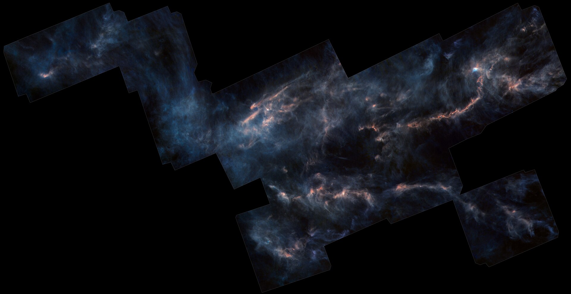 Este mosaico combina várias observações da Nuvem Molecular de Touro realizadas pelo observatório Herschel da ESA. Localizado a cerca de 450 anos-luz de nós, na constelação de Touro, este vasto complexo de nuvens interestelares é onde uma miríade de estrelas está nascendo e é a grande região de formação estelar mais próxima. Observando o céu em comprimentos de onda do infravermelho distante e submilimétrico de 2009 a 2013, o Herschel conseguiu captar o brilho tênue dos grãos de poeira dispersos por essas nuvens. Os astrônomos podem usar esse brilho para rastrear o gás escuro onde a formação estelar se desenvolve. As áreas mais escuras e em tons de azul ao longo da imagem correspondem a porções mais frias e menos densas da nuvem, enquanto as regiões mais brilhantes e em tons de vermelho são os ambientes mais densos, onde a atividade de formação estelar é mais intensa. As regiões mais densas estão distribuídas ao longo de uma intrincada rede de filamentos, repleta de aglomerados brilhantes: as sementes de futuras estrelas. Este é um exemplo clássico das estruturas filamentosas que foram observadas pelo Herschel em quase todos os lugares da Galáxia, demonstrando o papel fundamental dos filamentos na formação estelar. Incorporado no aglomerado brilhante em direção ao canto superior esquerdo da imagem está Lynds 1544, um núcleo pré-estelar que mais tarde se tornará uma estrela. Aqui, o Herschel detectou vapor d'água – a primeira vez que essa molécula foi encontrada em um núcleo pré-estelar – em uma quantidade que excede, em mais de 2.000 vezes, o conteúdo de água dos oceanos da Terra. As observações do Herschel das estruturas emaranhadas no canto superior direito da imagem mostraram que o material ao longo dos filamentos não é estático. De fato, os filamentos mais proeminentes parecem estar extraindo matéria de seus arredores por meio de uma rede de filamentos de menor densidade, conhecidos como estrias, perpendiculares ao filamento principal. Nessas regiões, os astrônomos descobriram que os campos magnéticos tendem a ser perpendiculares aos filamentos mais densos, formadores de estrelas, e paralelos às estrias, indicando que também devem desempenhar um papel importante nos processos que levam ao nascimento estelar. Esta imagem em quatro cores combina observações do Herschel em 160 micrômetros (azul), 250 micrômetros (verde), 350 micrômetros (divididos entre verde e vermelho) e 500 micrômetros (vermelho), e abrange 13,8° por 7,3°; o norte fica para cima e o leste para a esquerda. Matéria completa: A trilha cósmica de água descoberta pelo Herschel