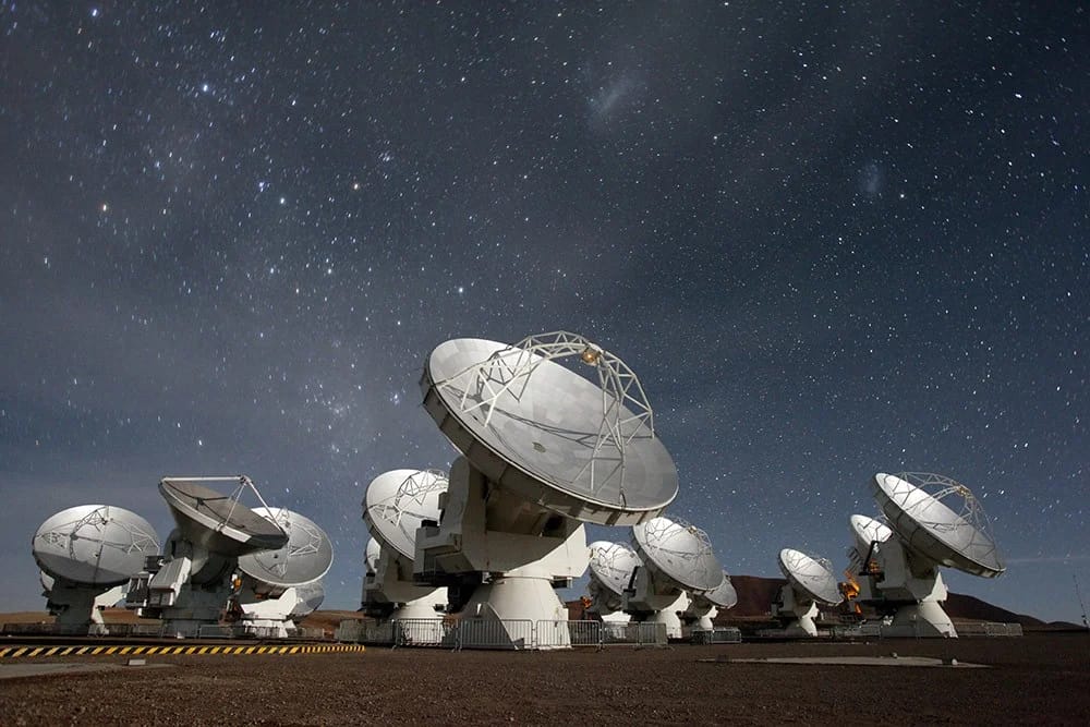 Vista panorâmica do ALMA Observatory, localizado no deserto de Atacama, Chile. O ALMA é uma das instalações astronômicas mais avançadas do mundo, composta por uma rede de antenas que captam radiação submilimétrica e milimétrica para estudar o universo em detalhes impressionantes.
